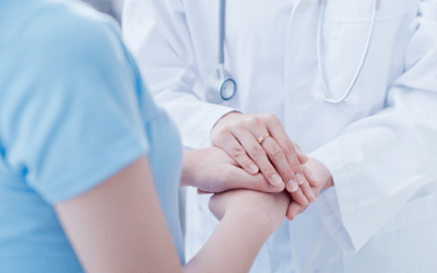 若い子宮がん患者の手を握る看護師